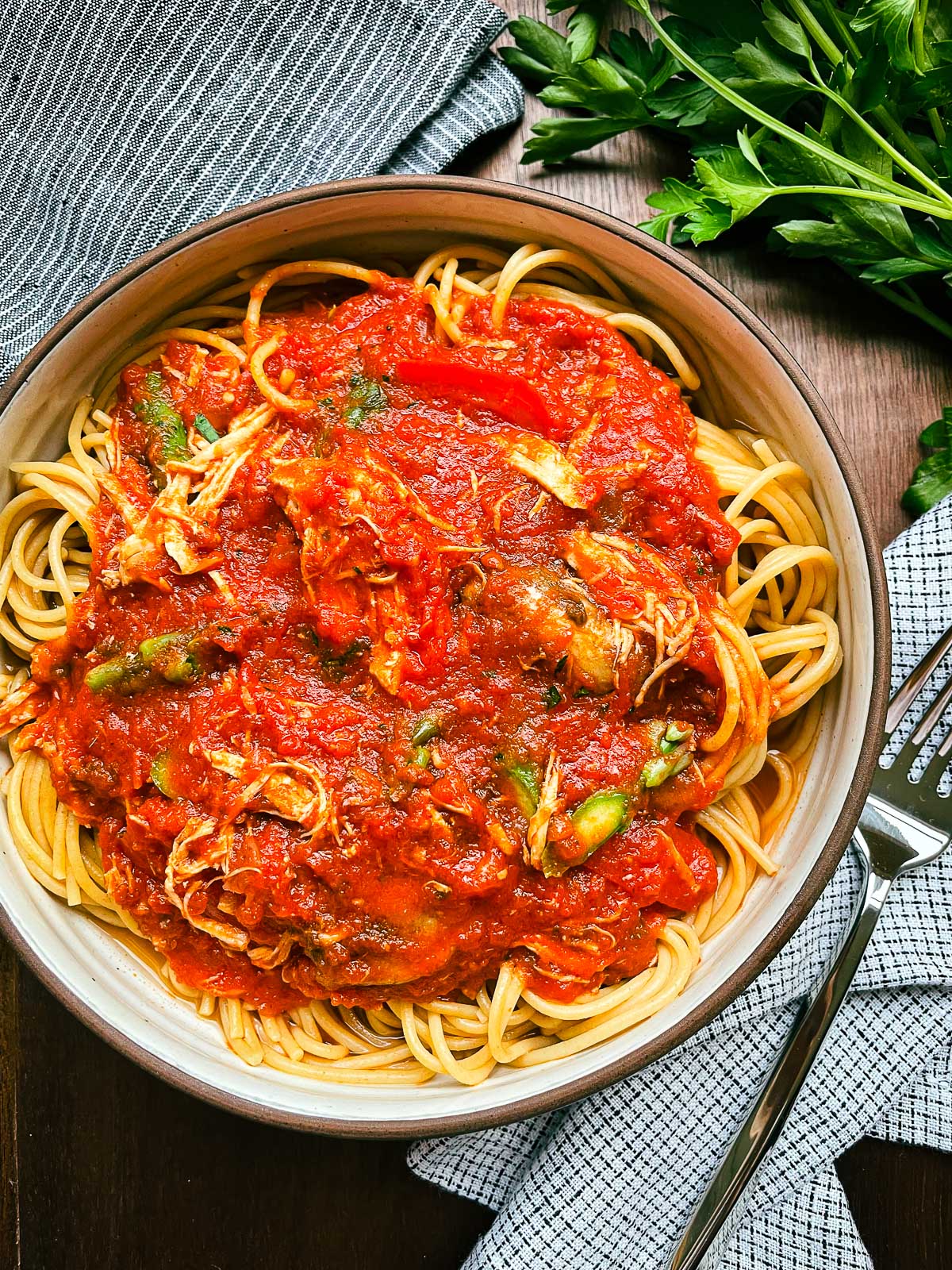 Chicken Cacciatore in a bowl over spaghetti.