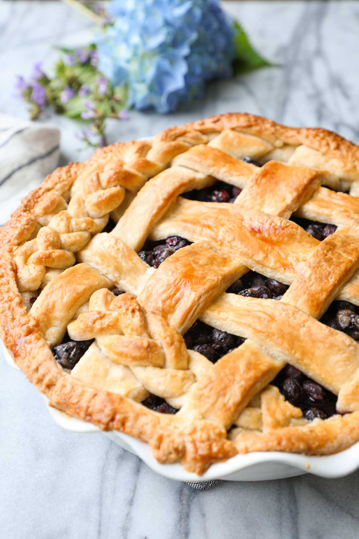 Side angle of this Classic Blueberry Pie with a woven lattice top.