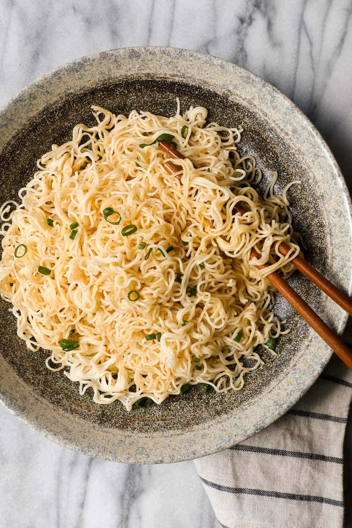 The Miso Butter Noodles in a dark grey bowl with chopsticks.