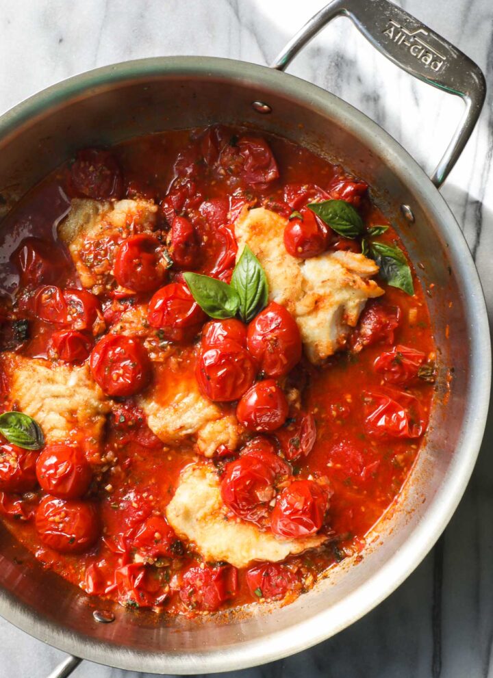 Pan Seared Cod in a White Wine Tomato Basil Sauce in a large saute pan.