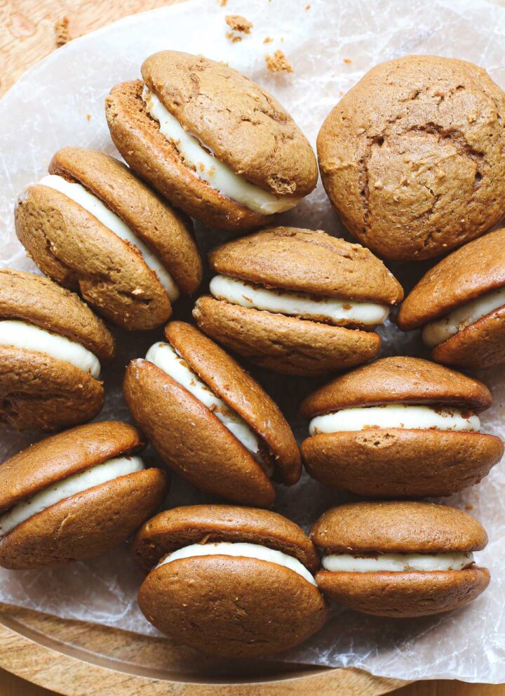 Gingerbread whoopie pies so that both the pies and the filling are visible on a brown background.