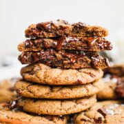 A stack of Espresso Chocolate Chunk Cookies, with half of the cookies broken in half exposing the melted chocolate interiors.
