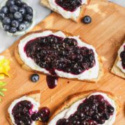 Blueberry Ricotta Toast on a wooden board, some cut into smaller pieces.