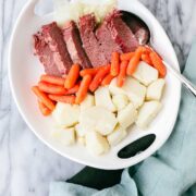 Corned beef, potatoes, carrots, and cabbage arranged on a serving platter.
