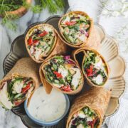 Three Chicken Spinach Wraps cut in half and arranged in a bowl with a side of homemade ranch dressing.