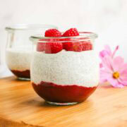 A jar layered with raspberry jam, chia seed pudding, and fresh raspberries.