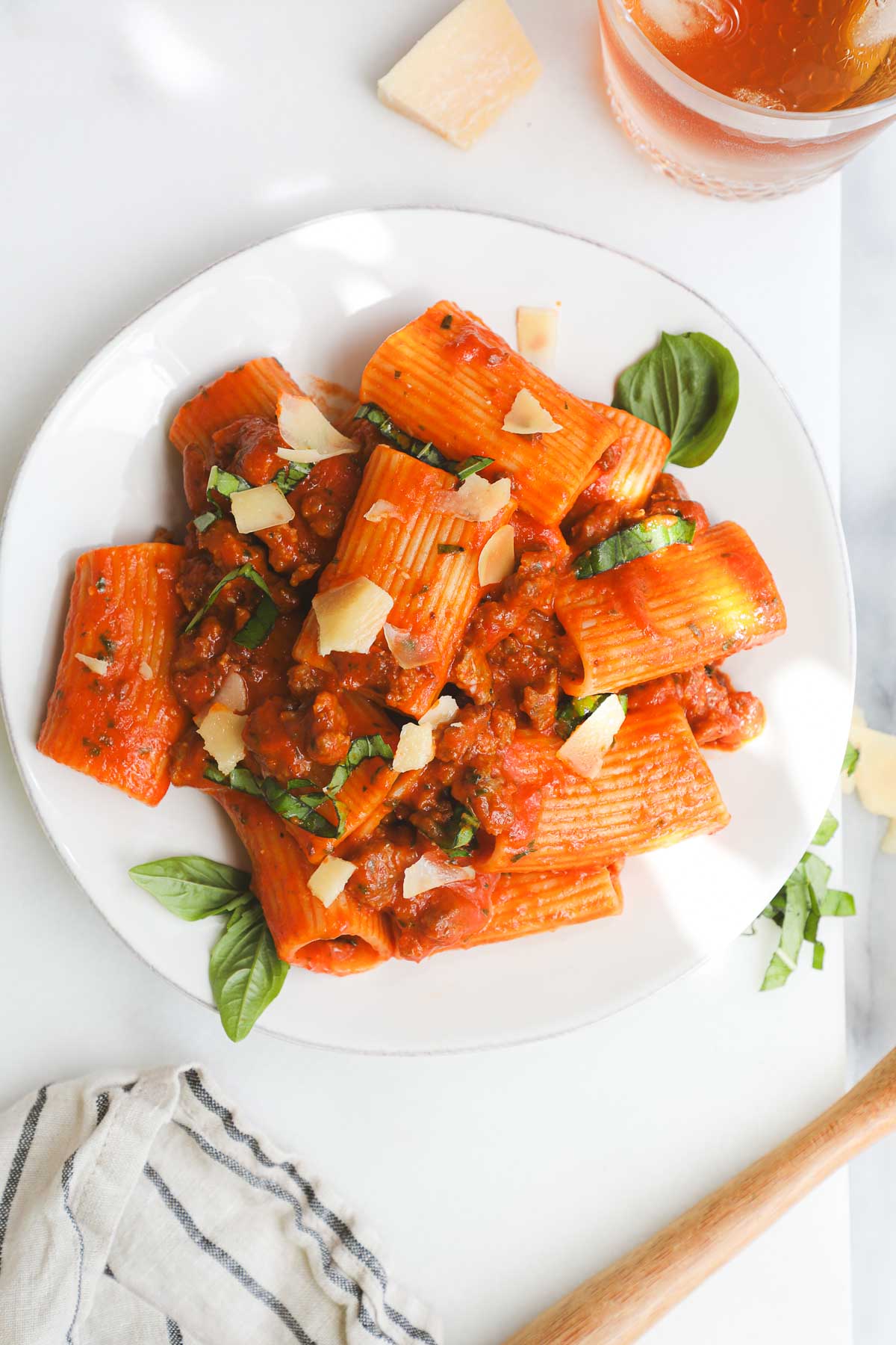 A plate of Homemade Cherry Tomato Sauce Pasta with Italian Sausage with parmesan and basil for garnish.
