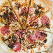 Hot Honey Meat Pizza on a pizza peel cut into slices.