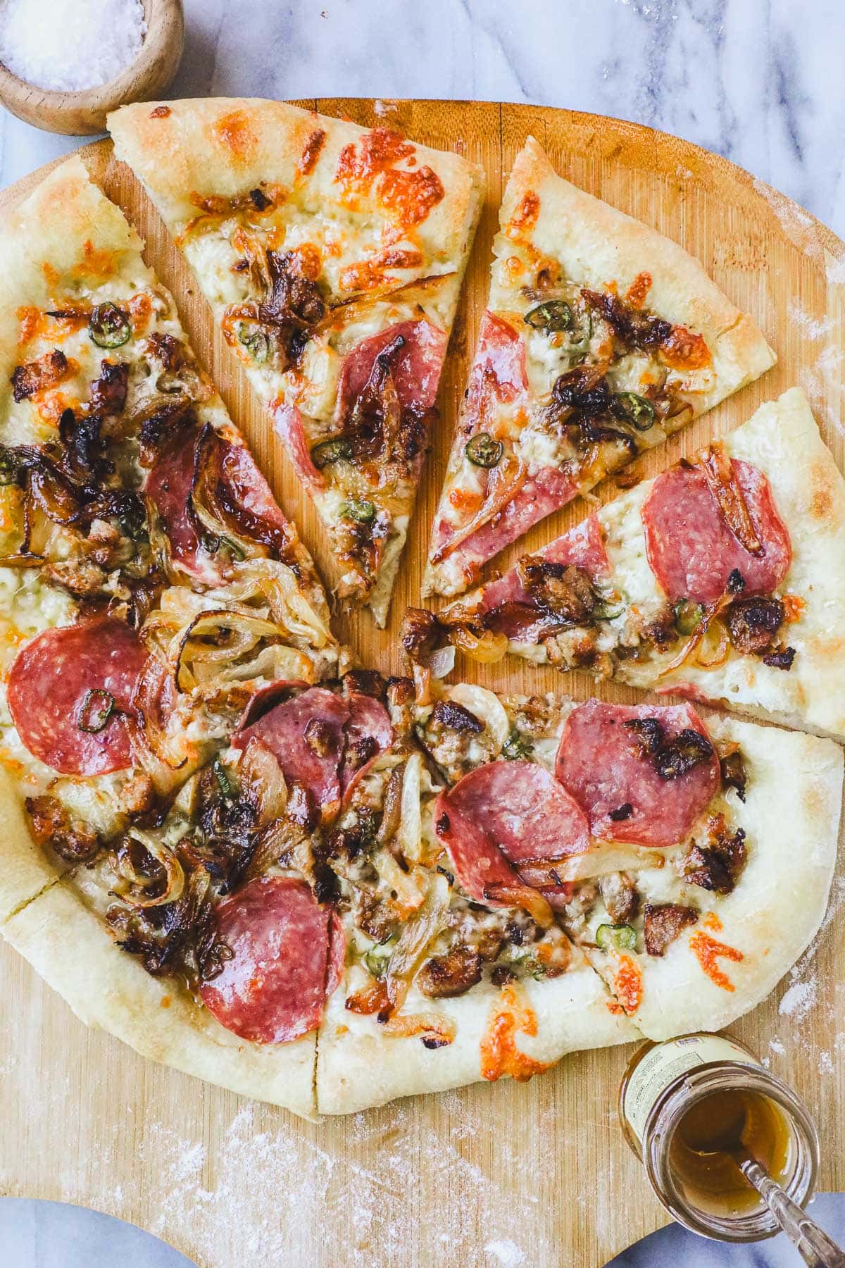 Hot Honey Meat Pizza on a pizza peel cut into slices.