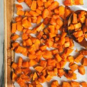 A golden sheet pan with diced and Maple Roasted Butternut Squash.