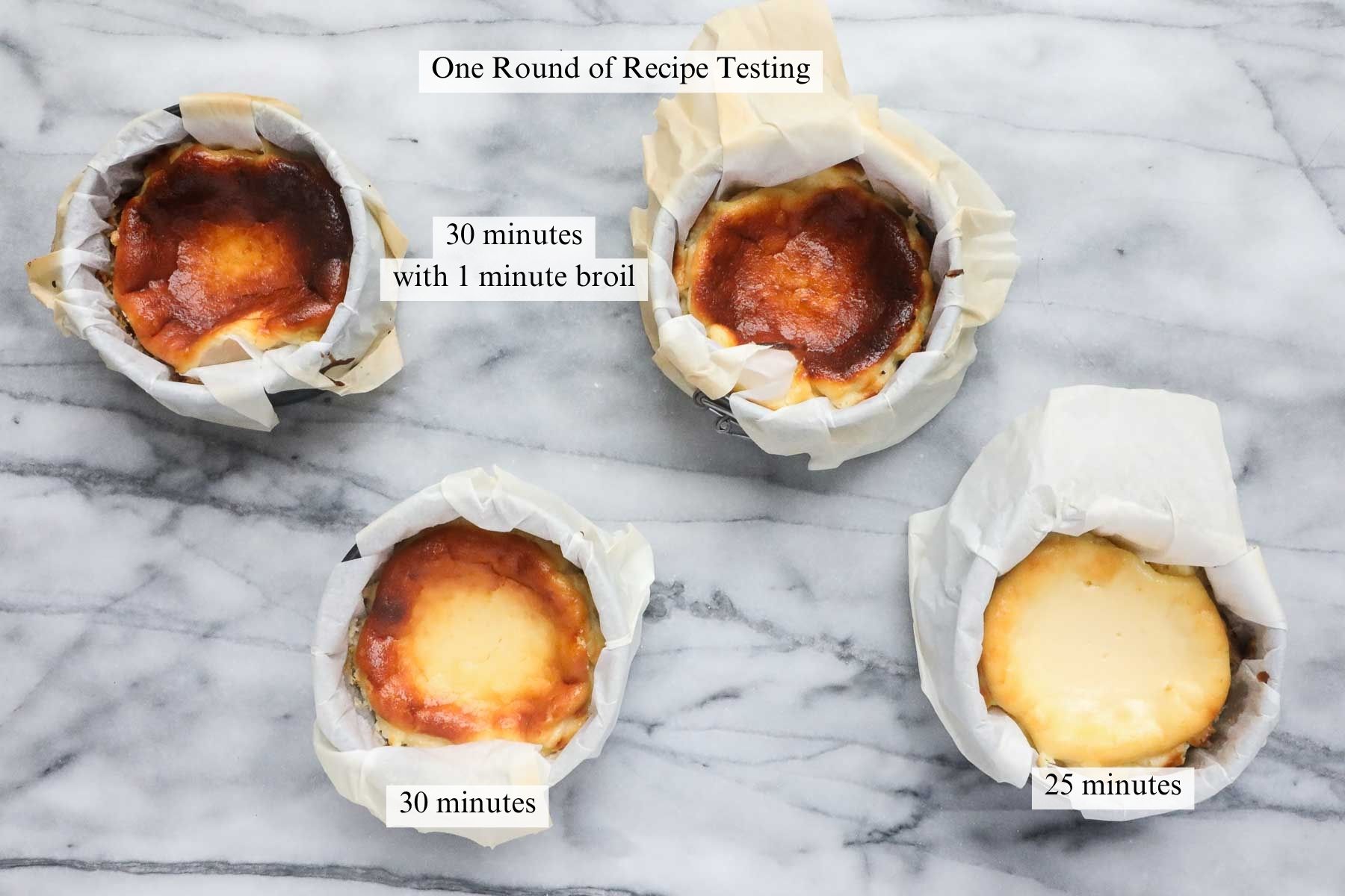 Four mini cheesecakes each with a different amount of caramelization on top based on different baking times.