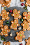 Cut Out Gingerbread cookies decorated with royal icing and colorful icing buttons displayed on a black marble serving dish.