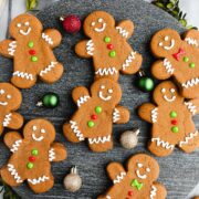 Cut Out Gingerbread cookies decorated with royal icing and colorful icing buttons displayed on a black marble serving dish.