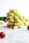 Soft Cut Out Sugar Cookies decorated with green sugar stacked on top of each other.