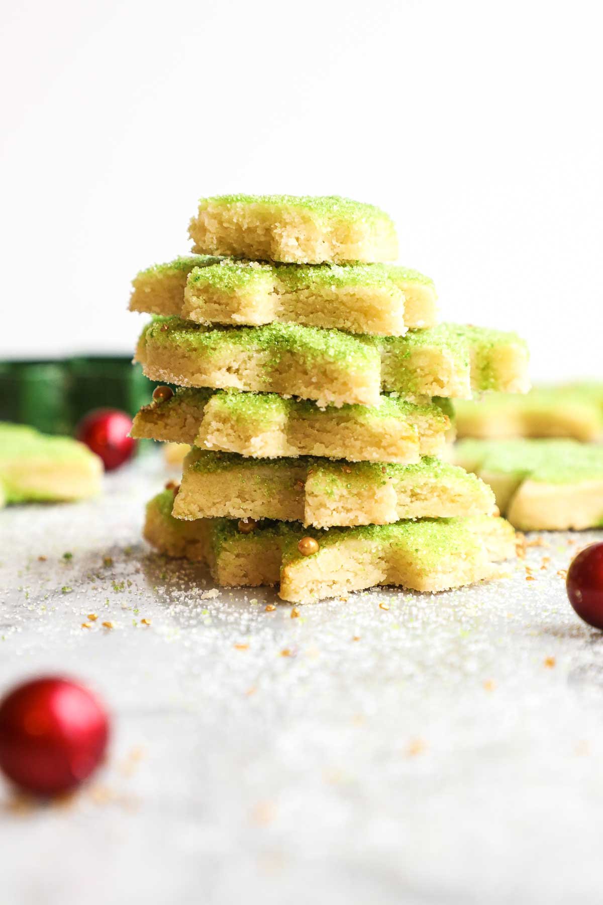 Soft Cut Out Sugar Cookies decorated with green sugar stacked on top of each other.