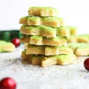 Soft Cut Out Sugar Cookies decorated with green sugar stacked on top of each other.
