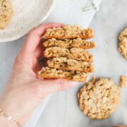 Lauren holding five Oatmeal Rice Krispie Cookies broken in half to show their texture.