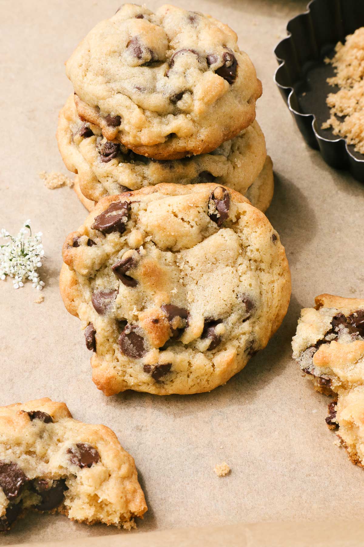 One chocolate chip cookie resting on a stack of chocolate chip cookies made without a mixer.