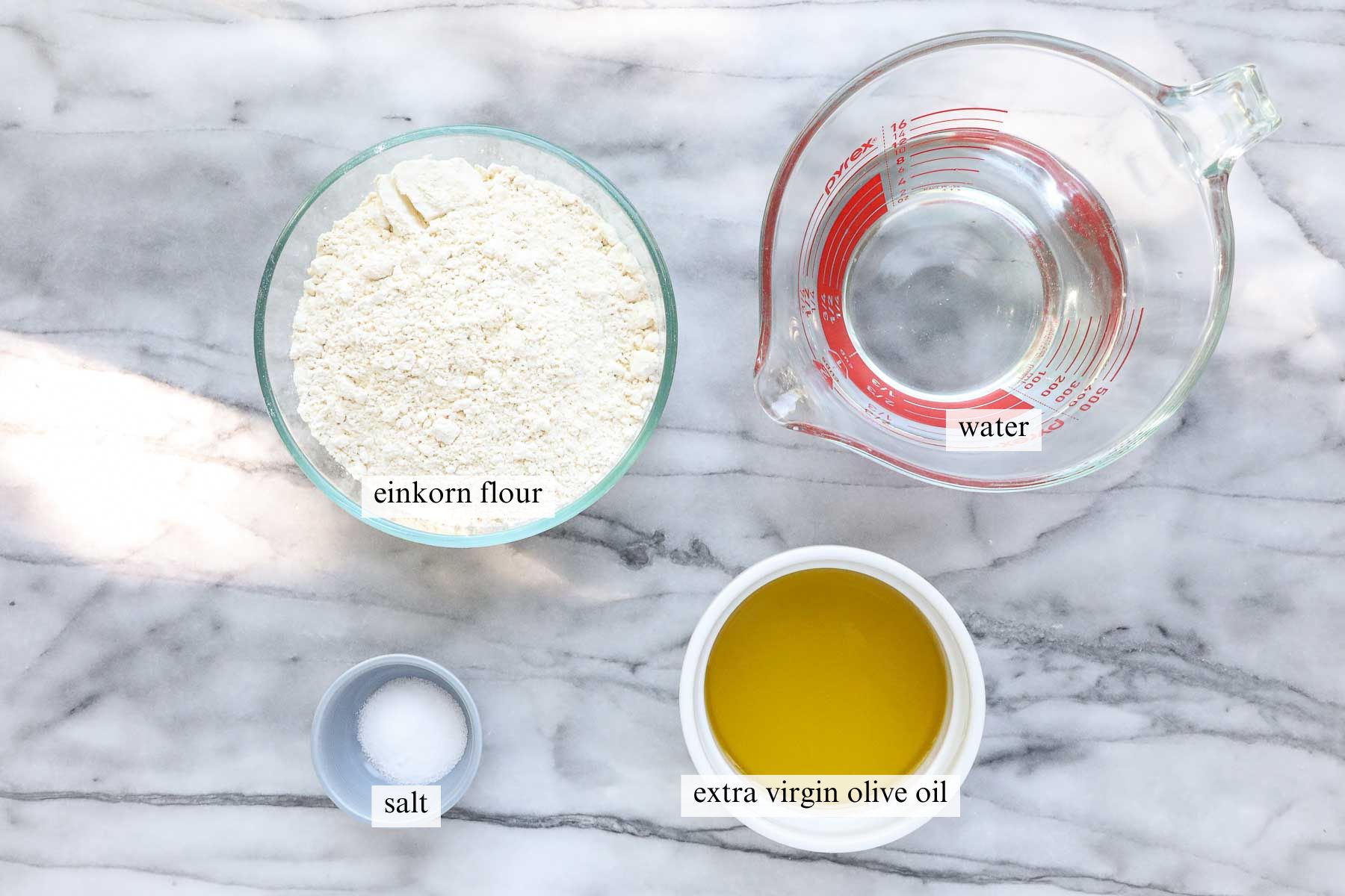 The ingredients needed to make Einkorn Tortillas including einkorn flour, salt, extra virgin olive oil, and water.