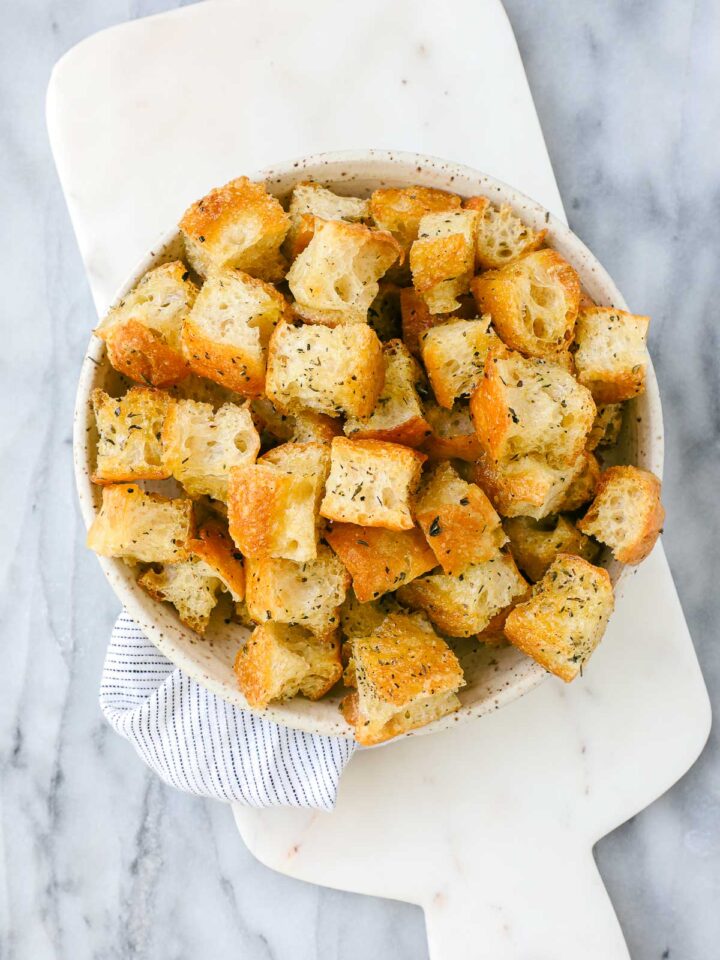Crispy golden focaccia croutons with Italian seasoning in a serving dish.