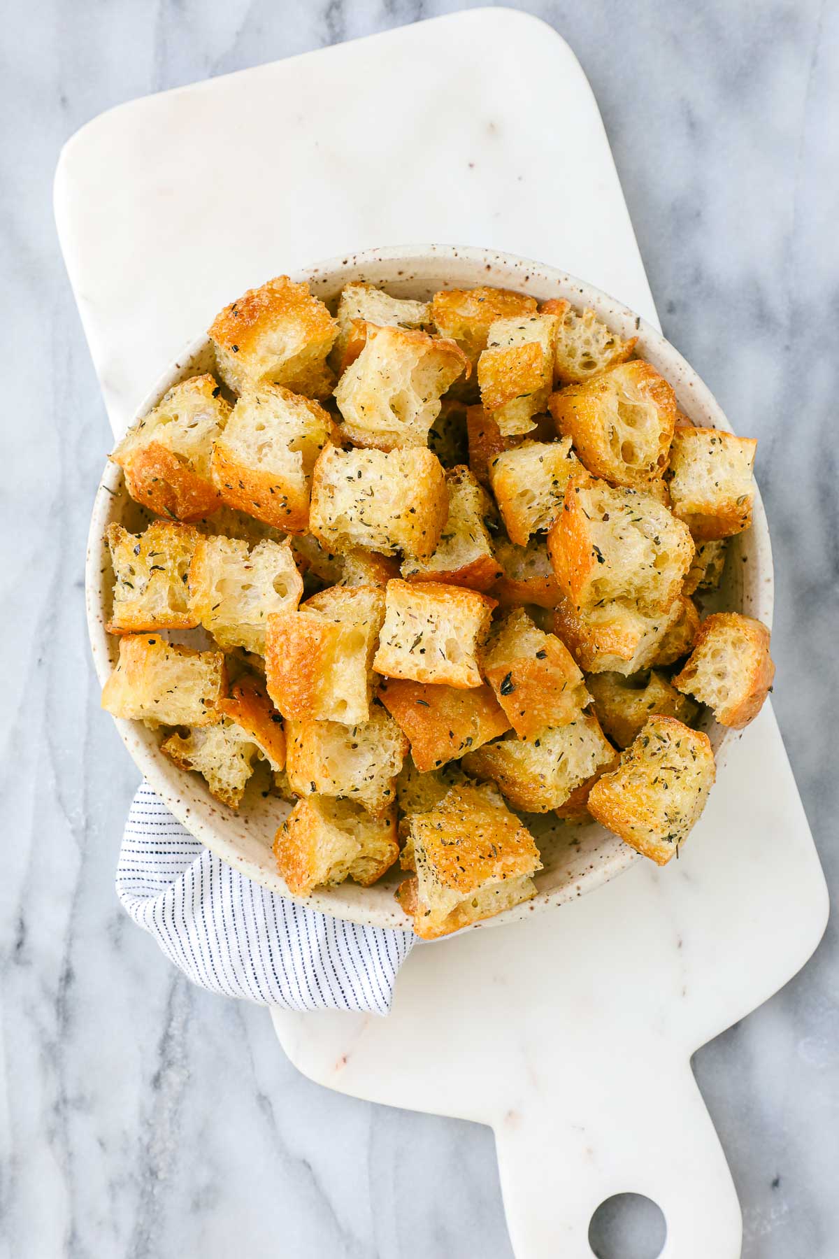 Crispy golden focaccia croutons with Italian seasoning in a serving dish.