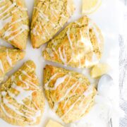 Olive Oil Scones arranged in a circle on a white background drizzled with lemon glaze.