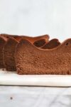 Slices of Chocolate Loaf Basque Cheesecake standing vertically slightly offset from one enough creating a wave pattern.