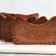 Slices of Chocolate Loaf Basque Cheesecake standing vertically slightly offset from one enough creating a wave pattern.