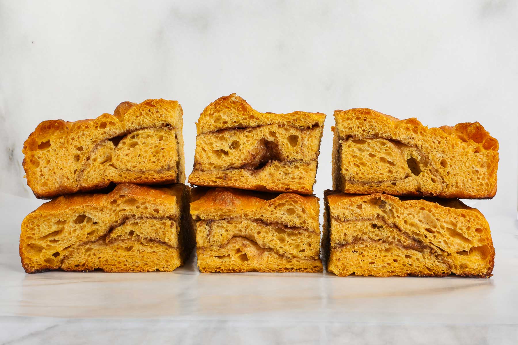 Cross section of the Sweet Pumpkin Focaccia showing the soft bubbly interior and cinnamon sugar swirl.